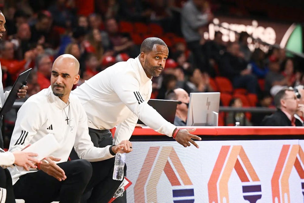 <p>Assistant head coach Carl Richburg directs players from sideline of a Miami University RedHawks basketball game.</p>