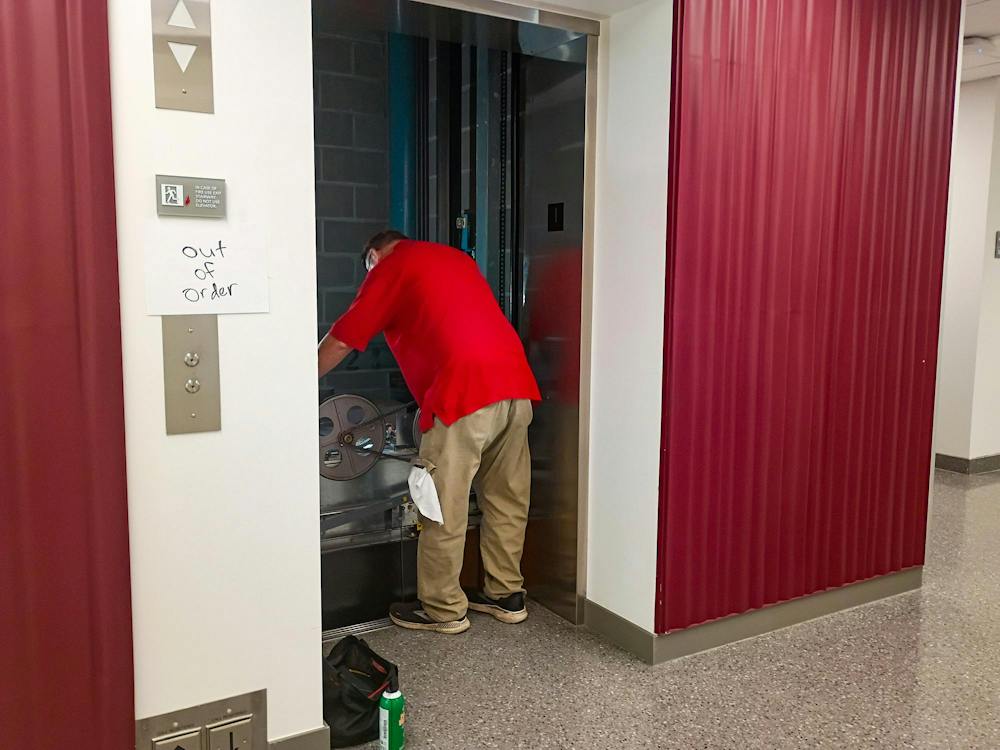 A maintenance worker fixes out of order elevator in Bachelor Hall.