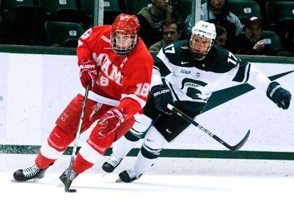 Junior captain Reilly Smith heads down the ice against Michigan State University’s Matt Crandell during a weekend series in East Lansing, Mich. Friday and Saturday. Miami’s sweep of the No. 15 Spartans gives them their third sweep of the season. 