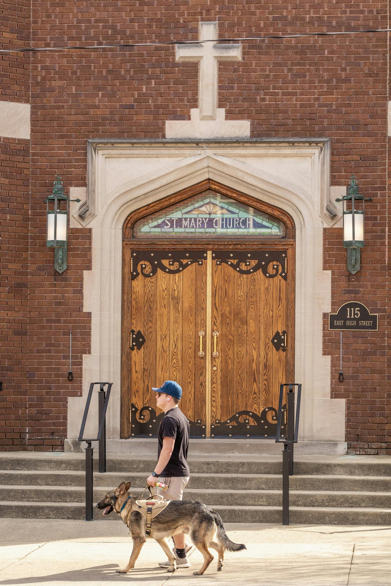 A man walks his dog in front of St. Mary church on High Street﻿