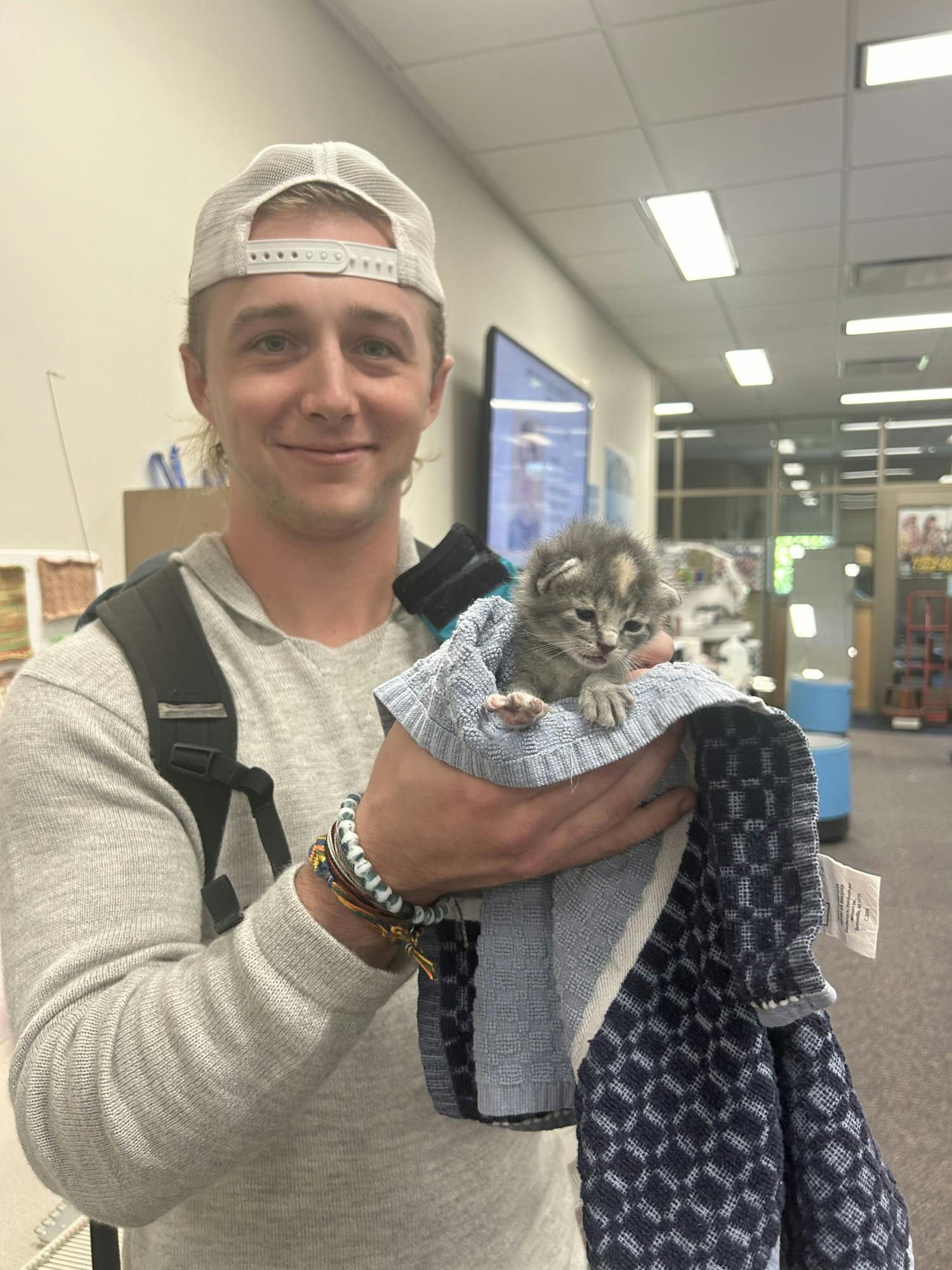 Teddy Johnson cheesing with an adorable kitten.