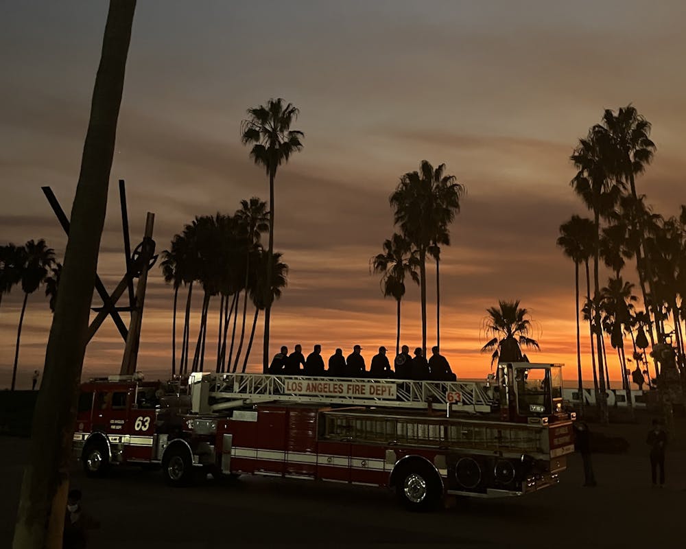 Firefighters of the Los Angeles Fire Department watch the sunset on Venice Beach after a long shift fighting the Palisades Fire. 