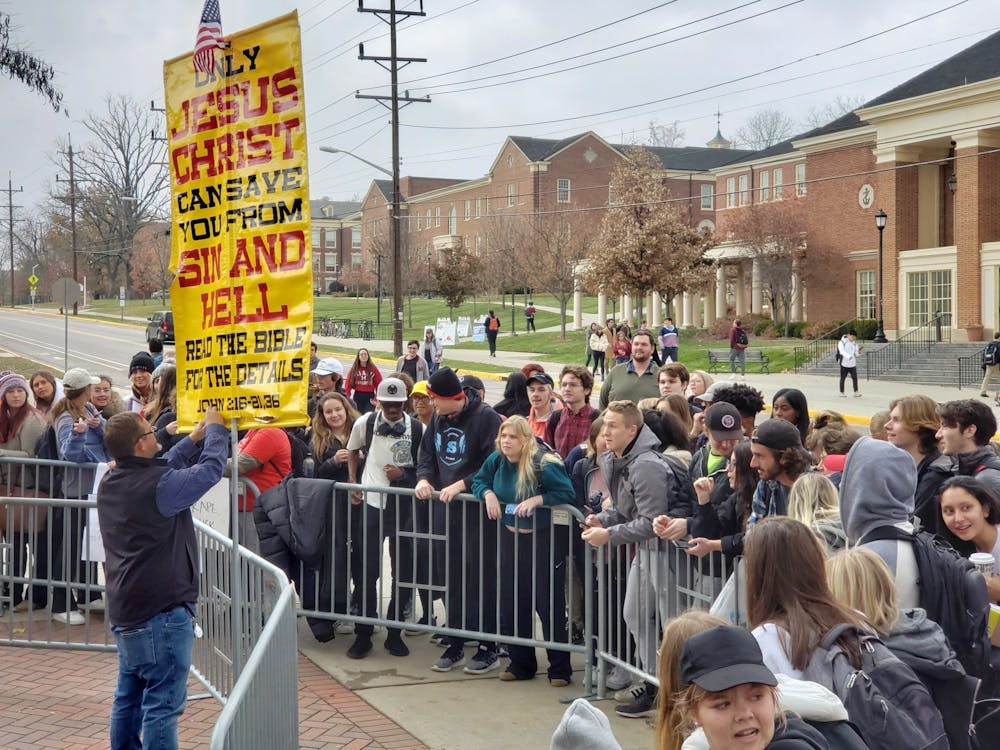 <p>Students shout back and forth with a street preacher at the corner of Spring and Maple. </p>