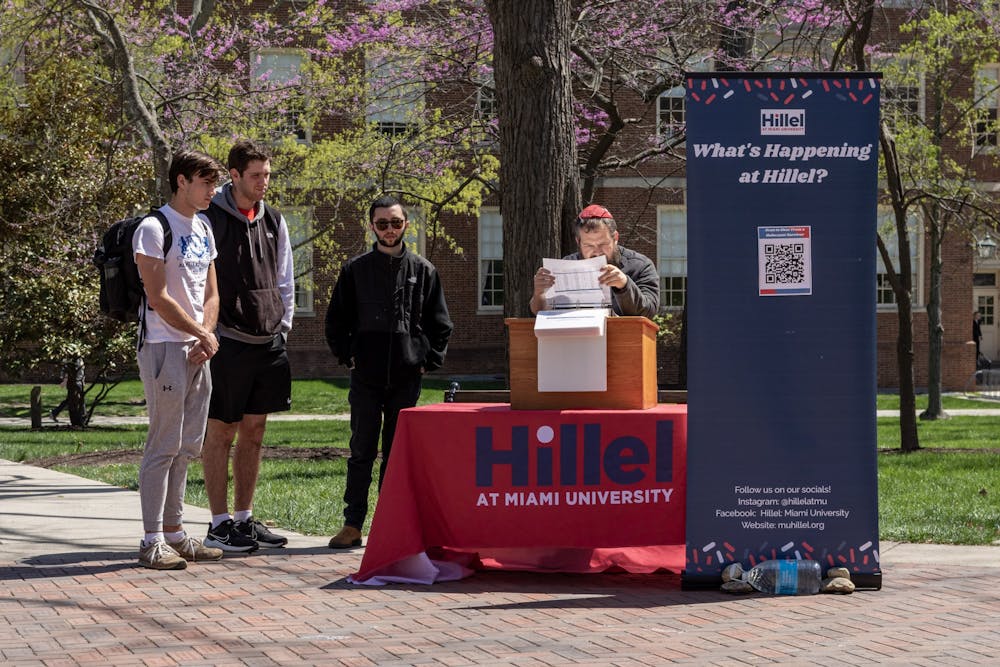<p>Students listen in on the reading of the names of Holocaust victims during Hillel at Miami&#x27;s Holocaust Remembrance Day memorial.</p>