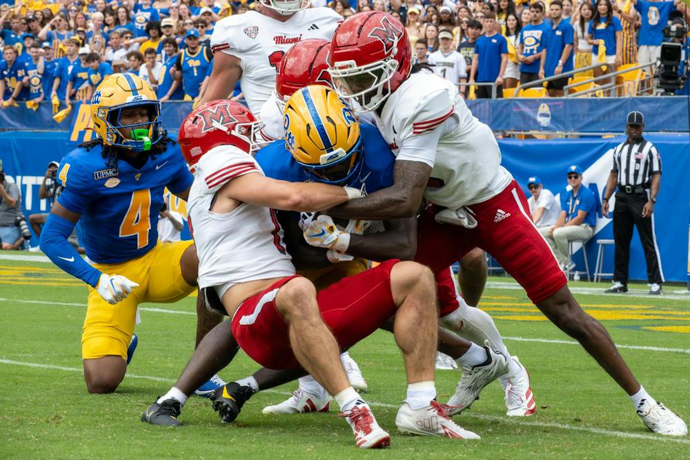 Defense tackles a player in the game against Pitt.