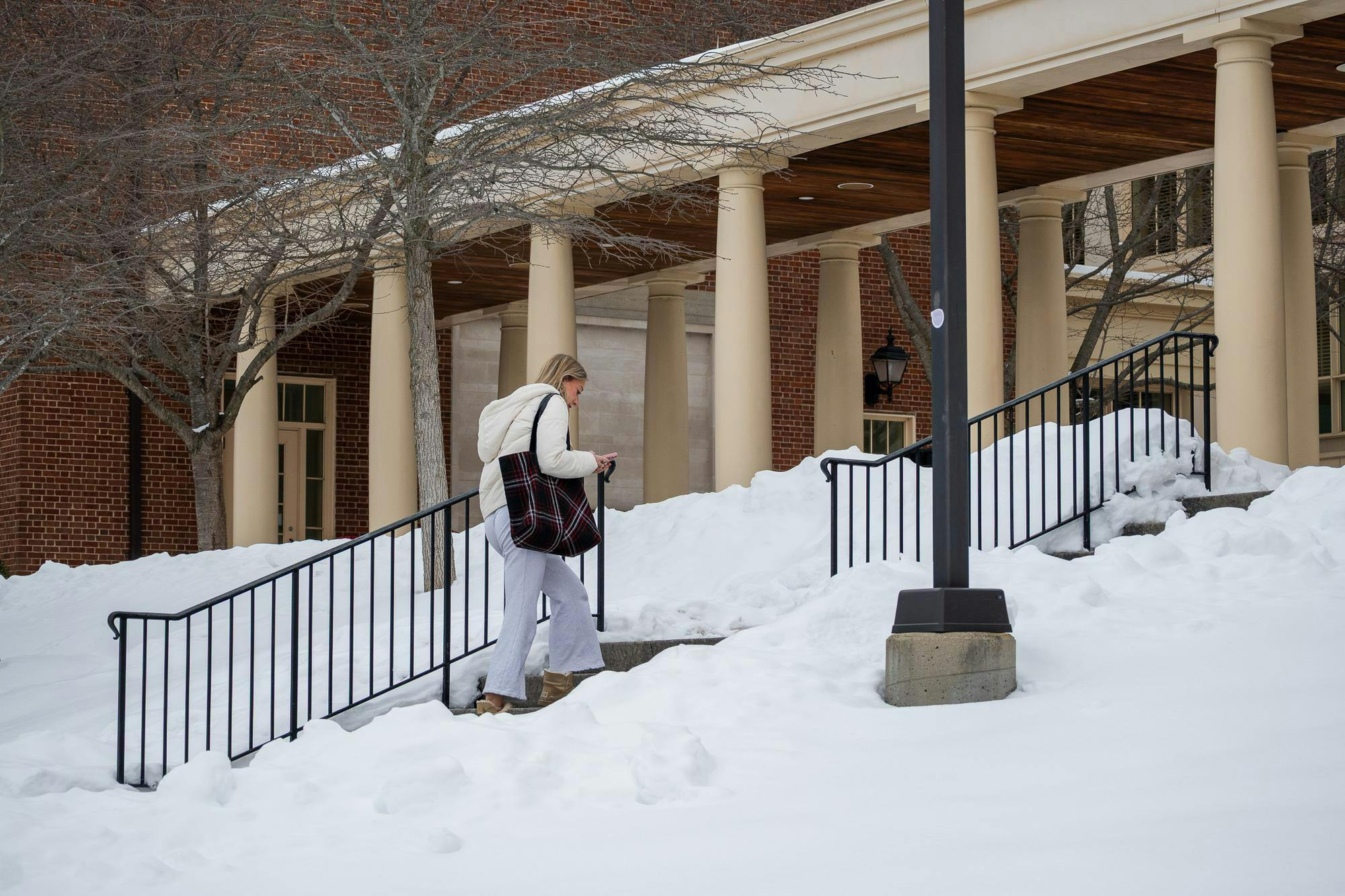 Student walks into Armstrong Student Center while looking down at her phone.