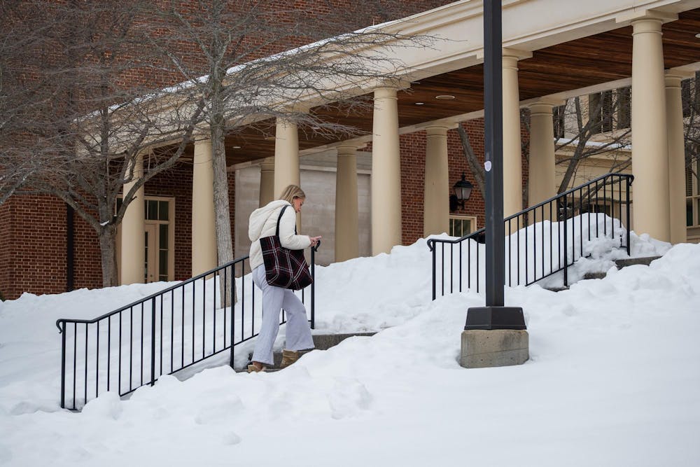 Student walks into Armstrong Student Center while looking down at her phone.
