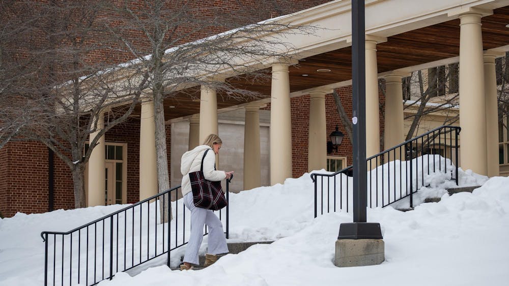 Student walks into Armstrong Student Center while looking down at her phone.