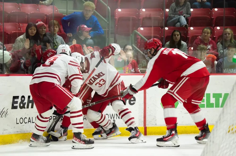 Students watch as the Miami University hockey teams grapples for the puck against Rensselaer Polytechnic Institute. 