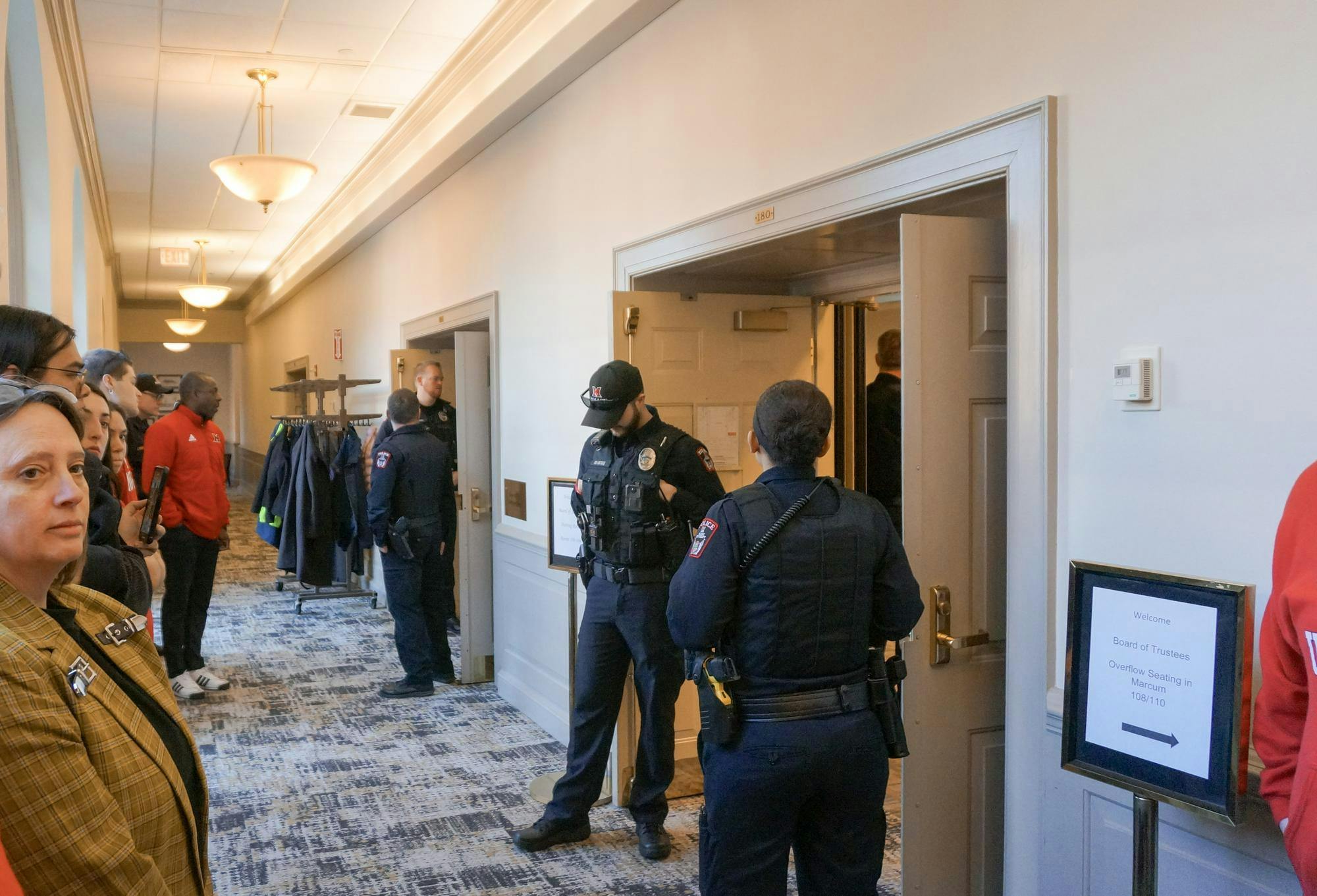 Campus police stand in front of the doors to the Miami Board of Trustees meeting.