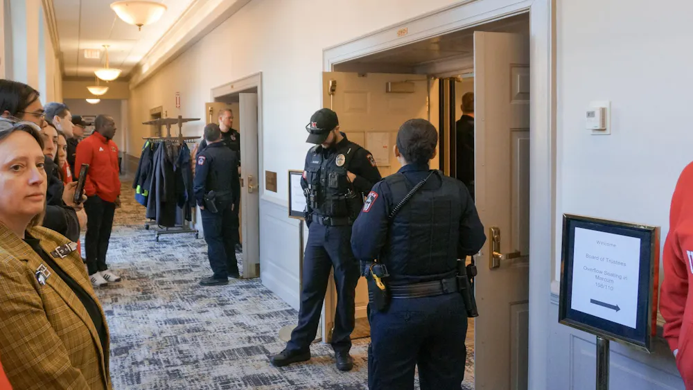 Campus police stand in front of the doors to the Miami Board of Trustees meeting.