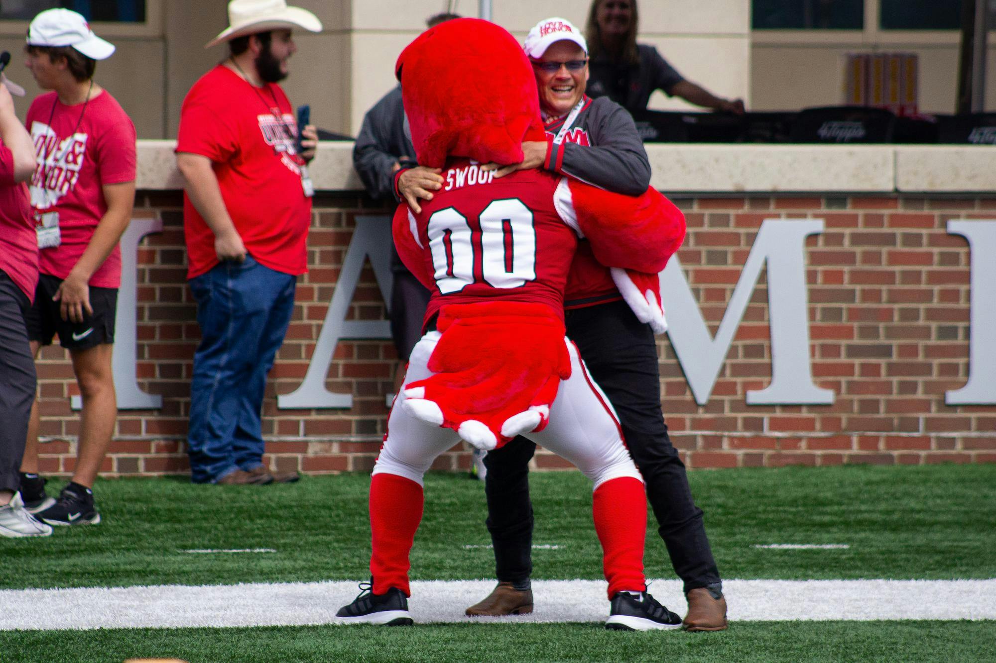 President Crawford embraces Swoop in endzone during game against the College of Holy Cross on Sept. 12.
