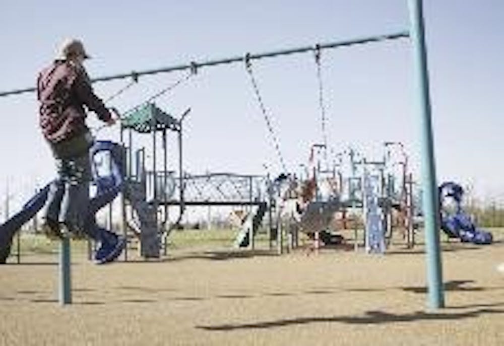 Local children play on the swings Monday afternoon at the Oxford Community Park playground, that will officially open with a ribbon cutting ceremony April 19.