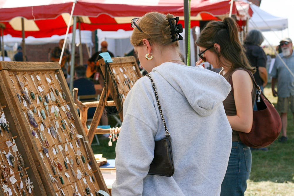 <p>Victoria Caputa and Ayla Peden browse pendants at the Hueston Woods annual Apple Butter Festival.</p>