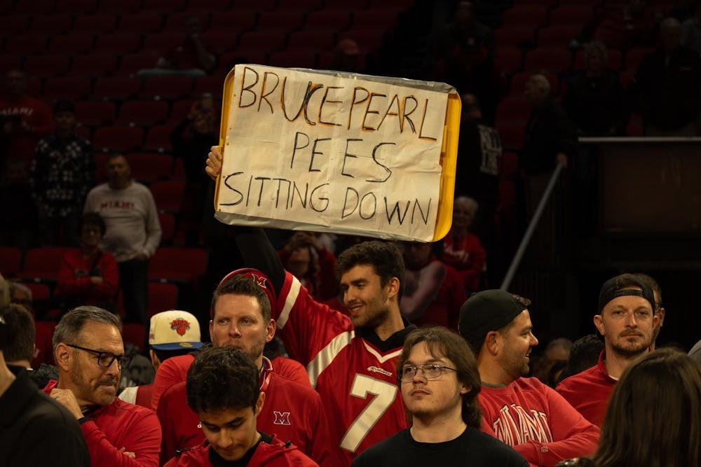 Fan stands on court holding a sign that reads ‘Bruce Pearl pees sitting down' after the Miami University RedHawks defeated the University of Toledo Rockets 74-72