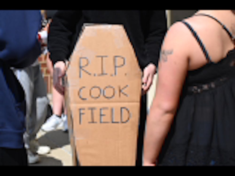 Student stands with cardboard coffin