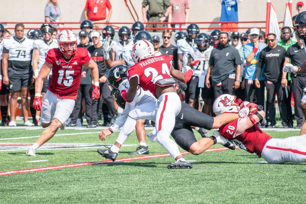 Mychal Yharbrough runs to avoid falling player in game against University of Cincinnati.