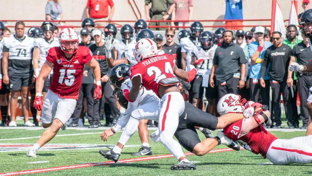 Mychal Yharbrough runs to avoid falling player in game against University of Cincinnati.