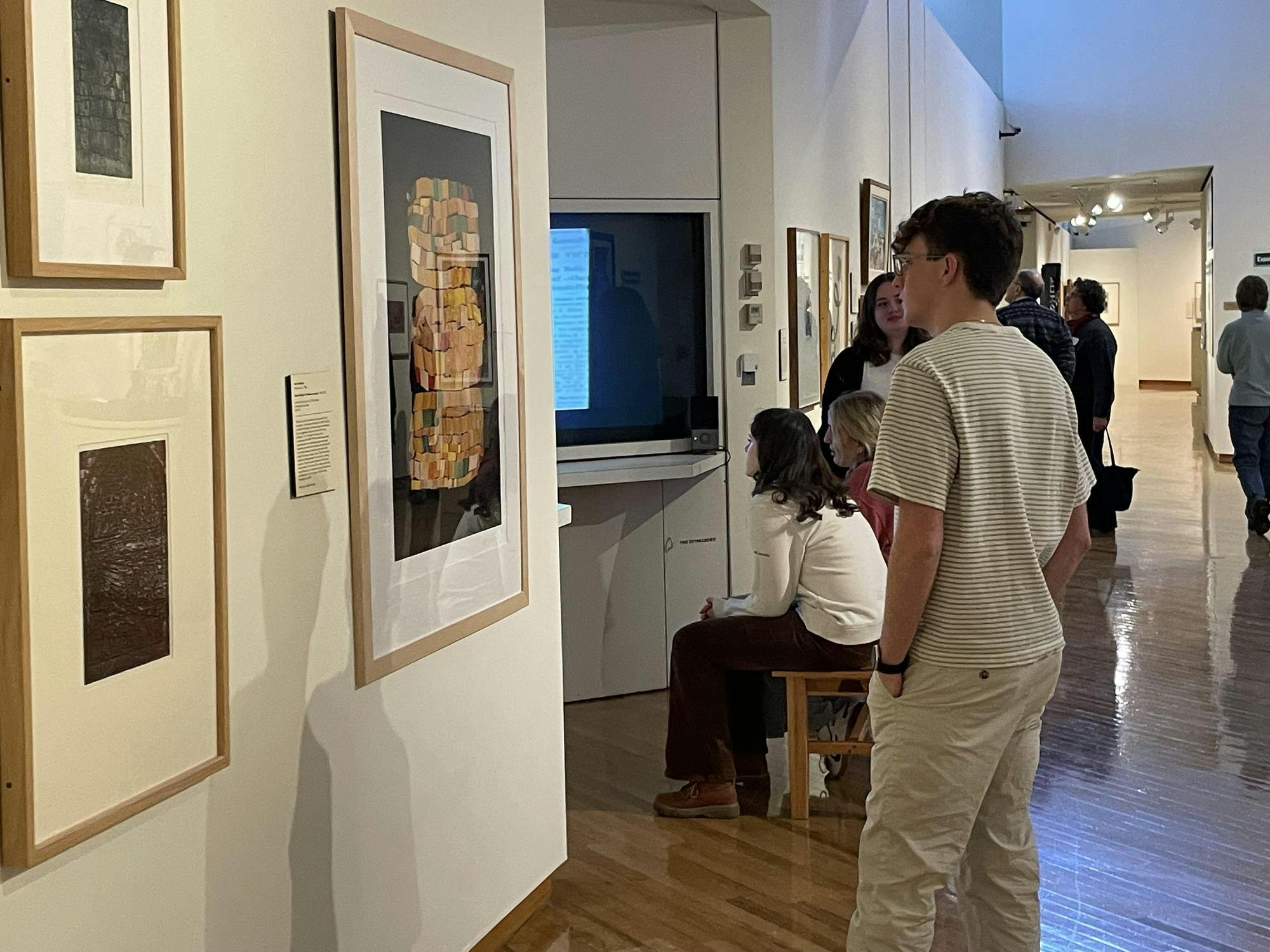 Sophomore Hayden Jarvis observes the new exhibition, "Rooted Here," at the Richard and Carole Cocks Art Museum.