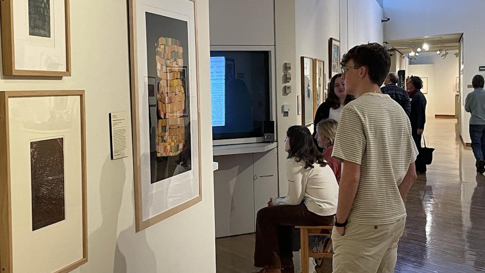 Sophomore Hayden Jarvis observes the new exhibition, "Rooted Here," at the Richard and Carole Cocks Art Museum.