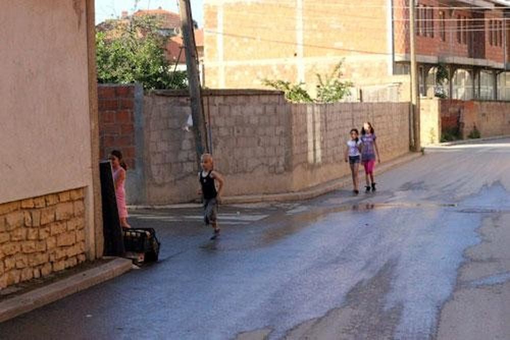 Children play together in the watered streets of a Roma community in the outskirts of Prishtina, the capital of Kosovo. 