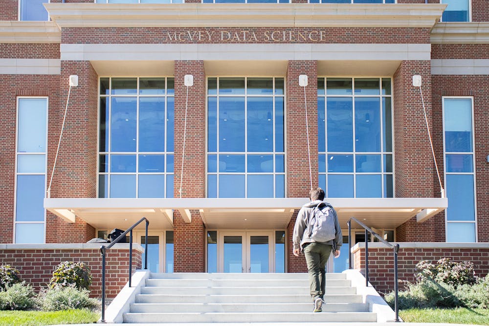 A student walks into one of Miami's newest campus buildings, the McVey Data Science building, which is certified LEED Silver.