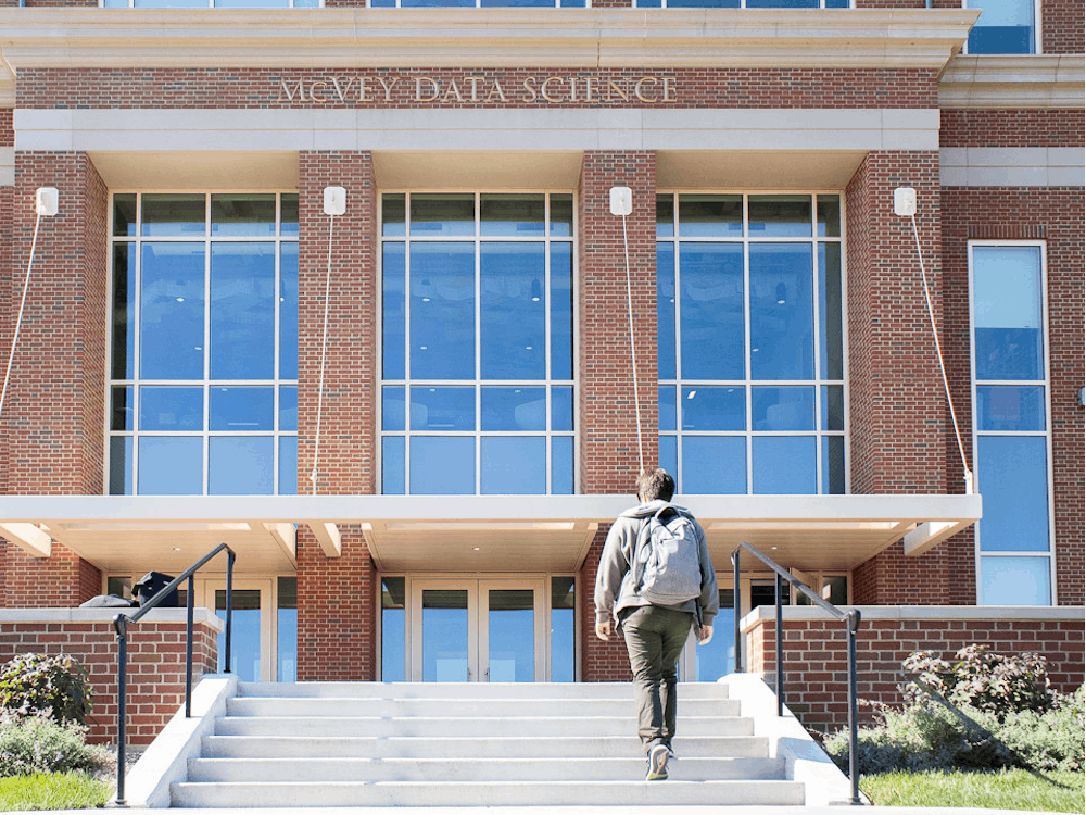A student walks into one of Miami's newest campus buildings, the McVey Data Science building, which is certified LEED Silver.
