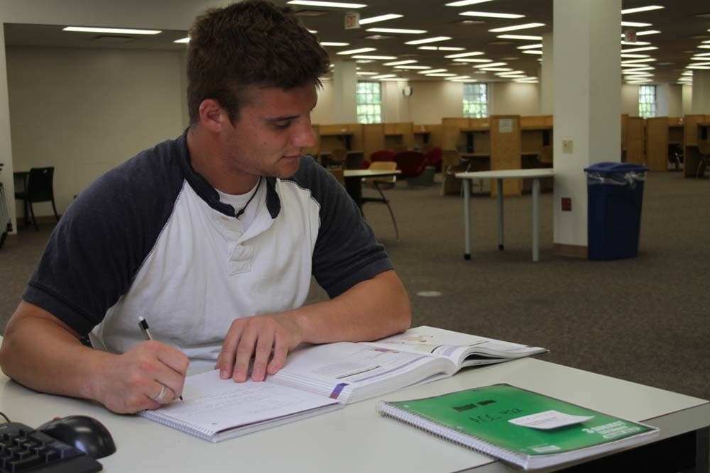 Senior Adam Vanicek takes a break from the heat outside and studies for summer courses in King Library.
