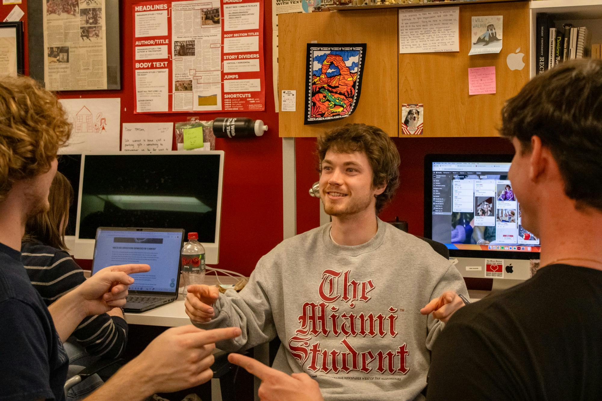 Sam Norton exits his writing cave, pointing at his fellow buddies in the corner, Kasey Turman and Adam Smith.