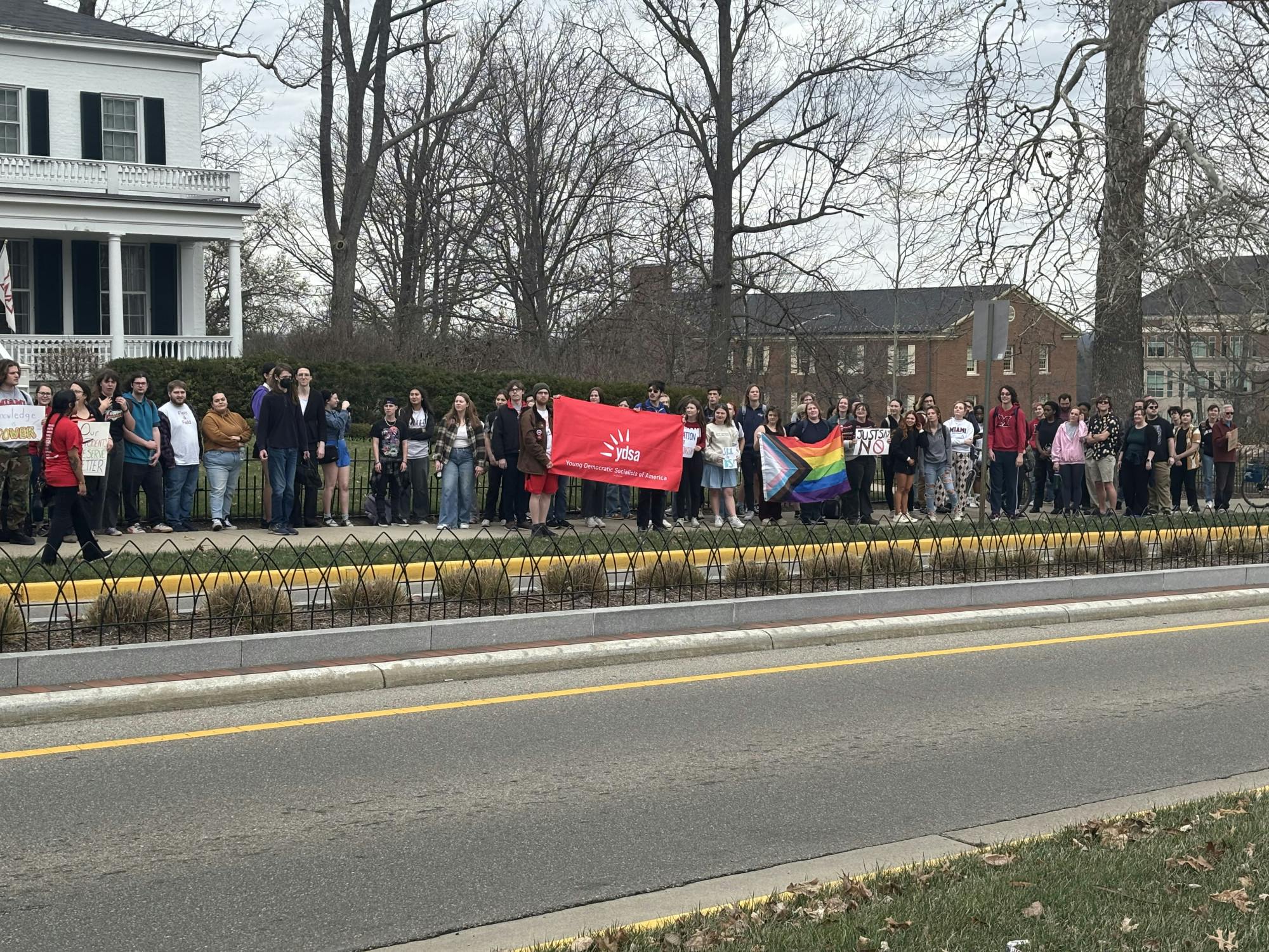 Students held flags and signs as they protested in front of Lewis Place.