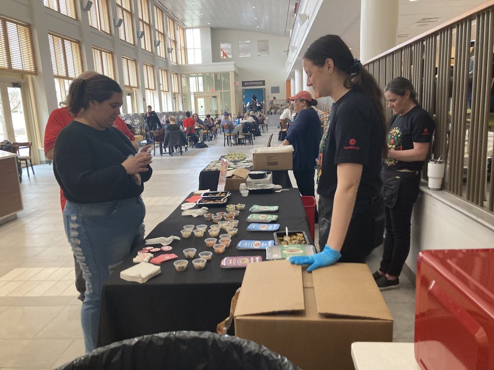 <p>Sophomore architecture major Kahleigh Wiest (left) taste-tested plant-based dishes from a booth run by rootberry personnel on Feb. 22.﻿</p>