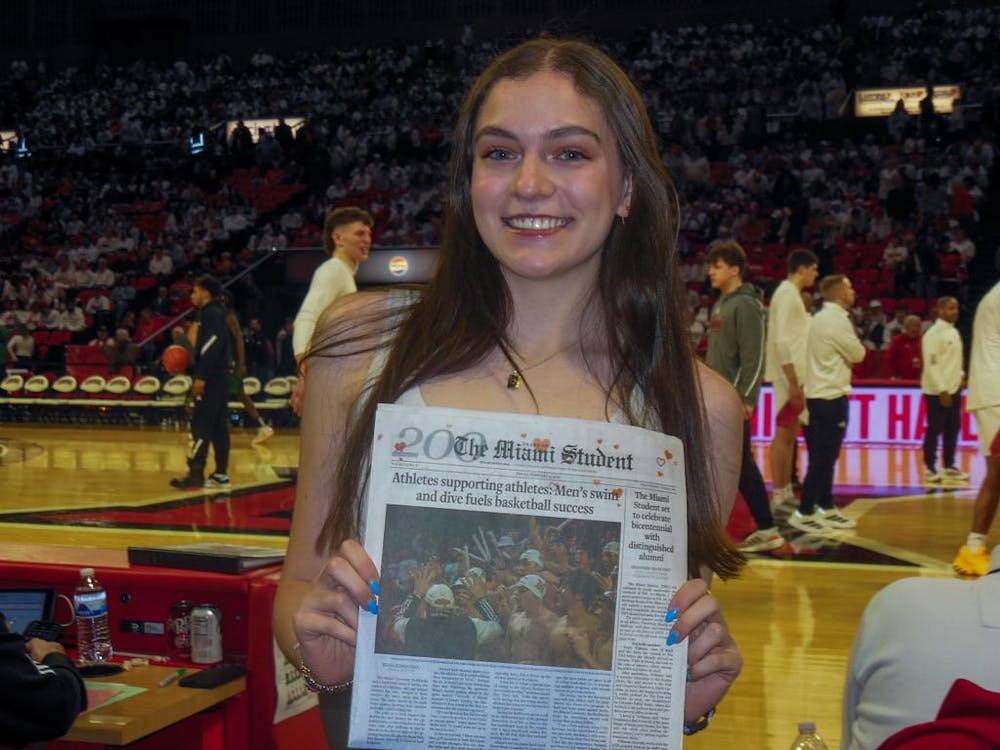 Elisa Rosenthal poses with her front-page story of the newspaper at the Miami basketball game.