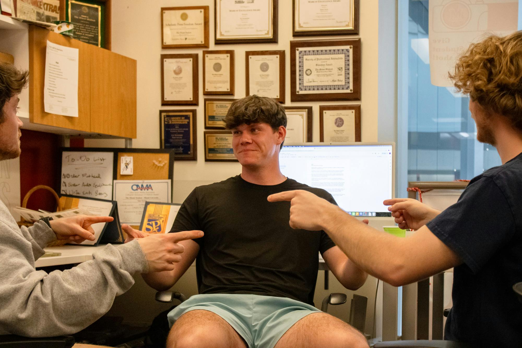 Adam Smith looks at his newsroom corner buddies, Sam Norton and Kasey Turman. 