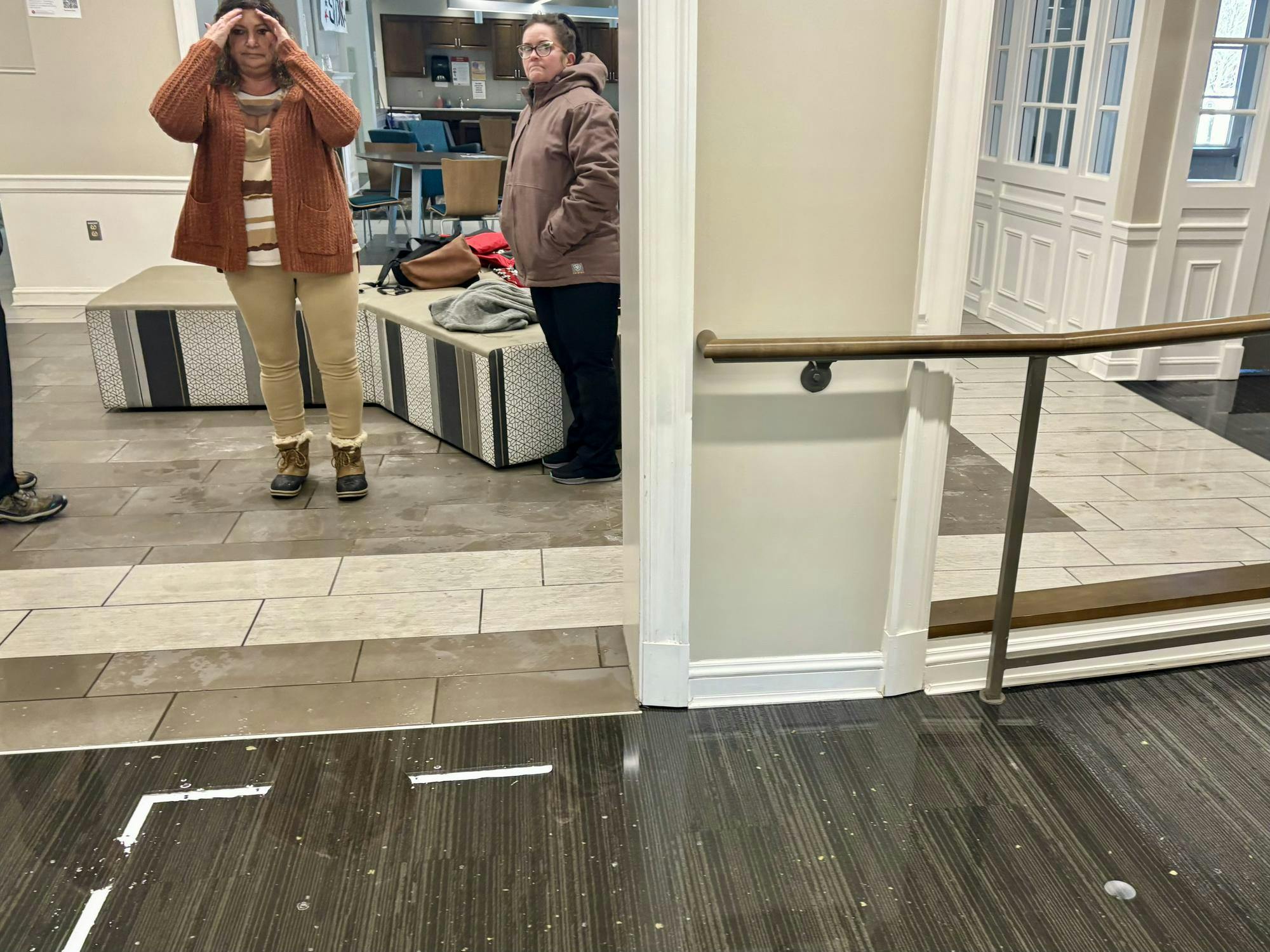 Two physical facilities employees assess the flood on the first floor of Stanton Hall.