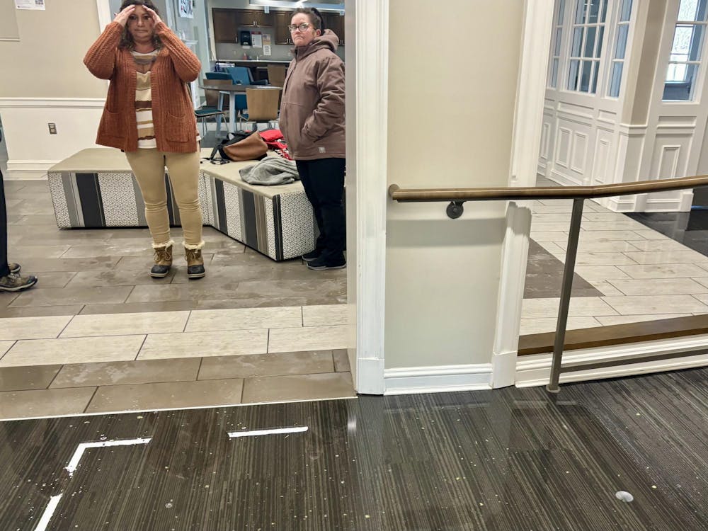 Two physical facilities employees assess the flood on the first floor of Stanton Hall.