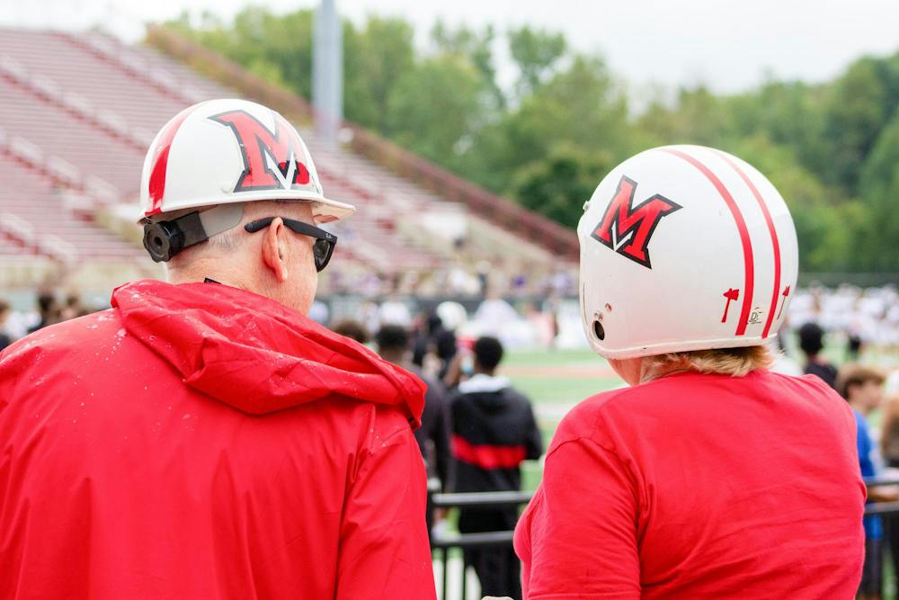 People watch the game against Holy Cross in Miami themed helmets.