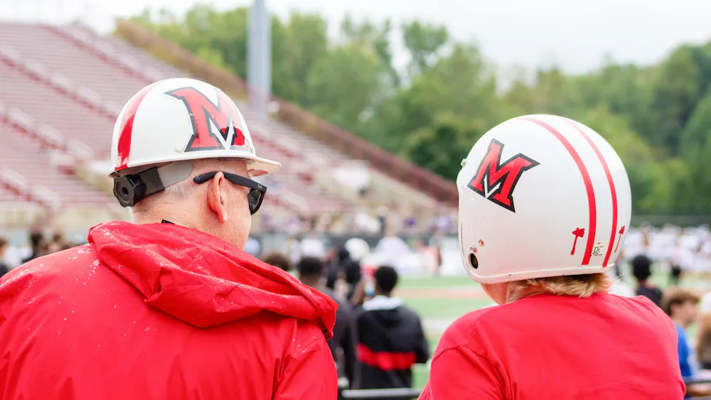 People watch the game against Holy Cross in Miami themed helmets.