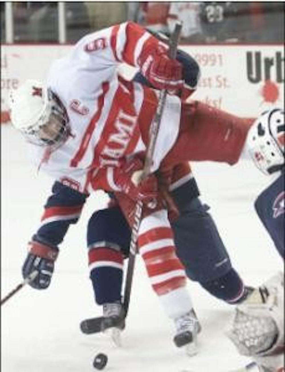 Tommy Wingels battles Robert Morris players for control of the puck (Michael Griggs / The Miami Student).
