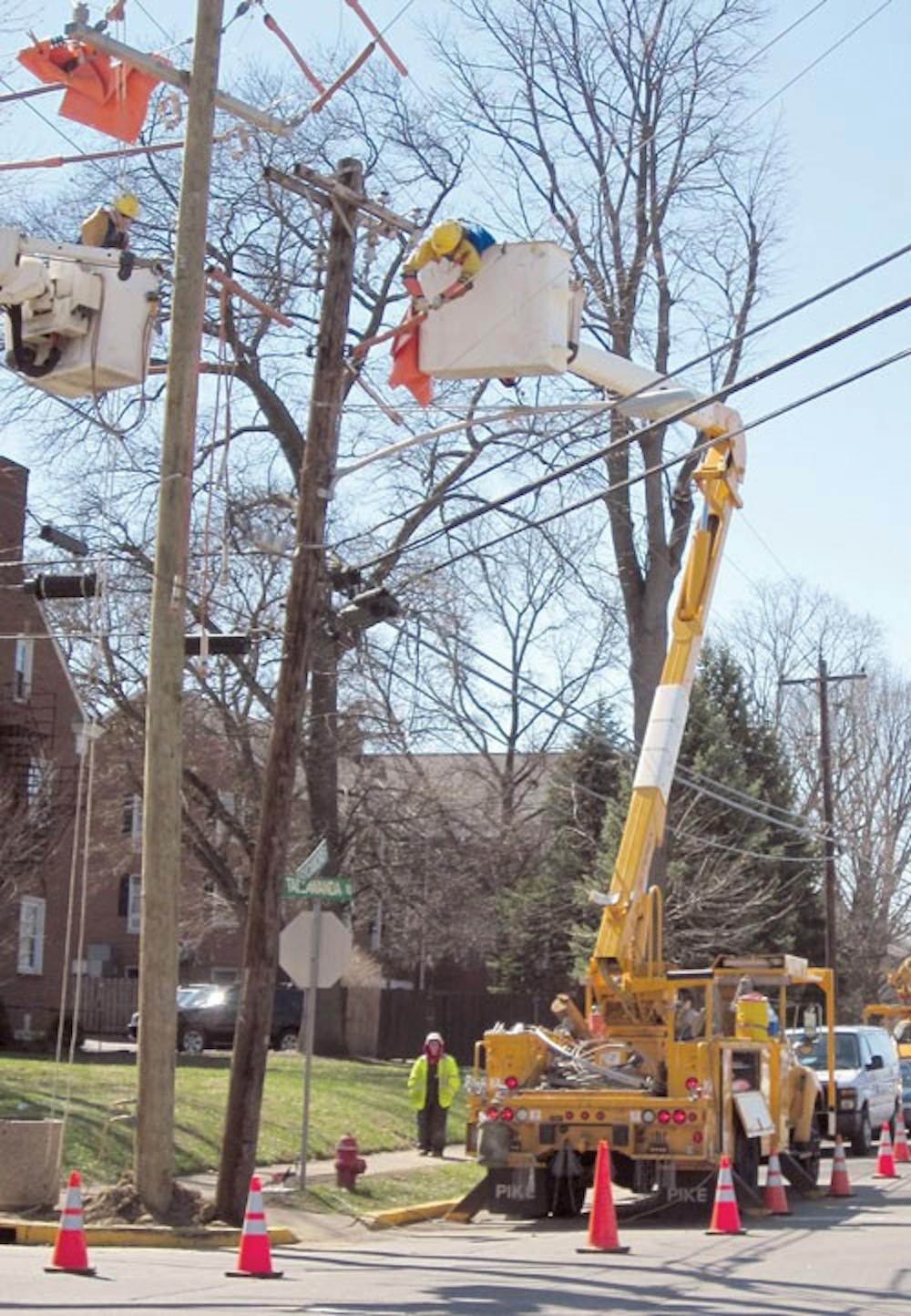 Linesmen keep powerlines intact in cherry pickers in a pole exchange March 28.