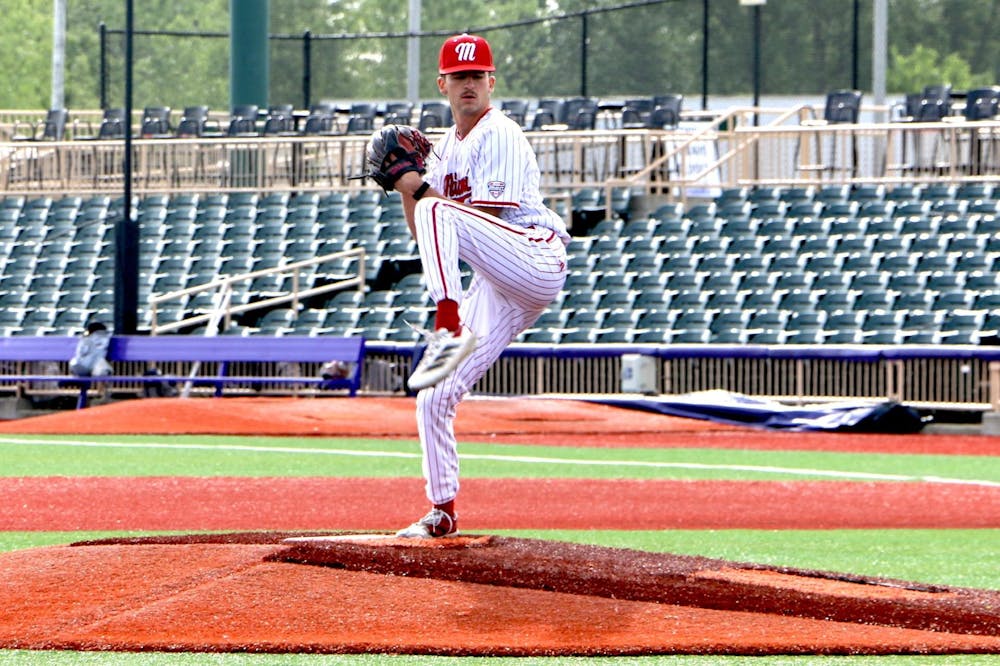 Graduate student Clayton Burke kicks to deal a pitch against Kent State on May 22