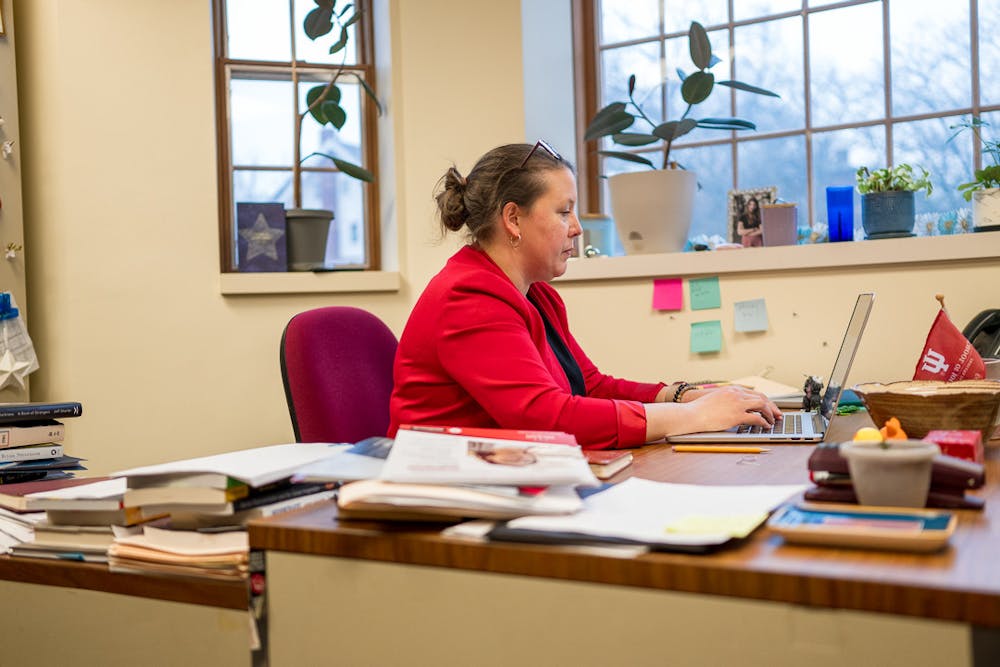 <p>Journalism Professor Rosemary Pennington works on grading student assignments in her office.﻿</p>