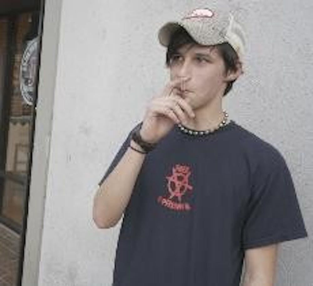 Oxford resident Paul Dudley smokes a cigarette Monday afternoon outside of Jimmy John's; an action that will soon be banned indoors. 