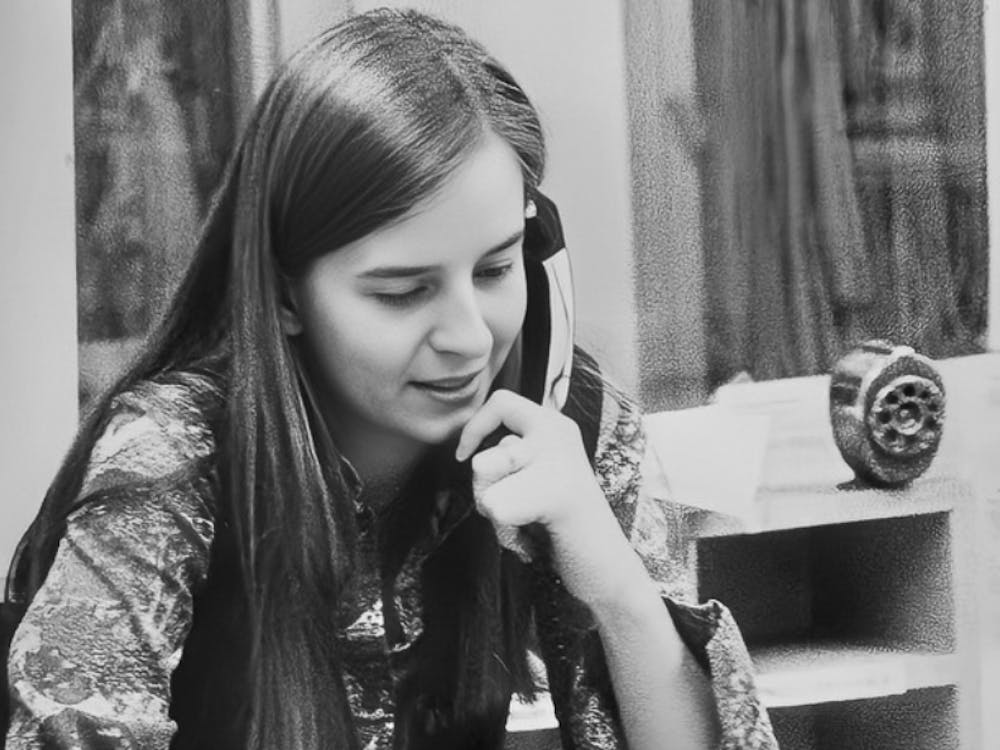 Sue MacDonald sitting on her desk in the editor's office of The Miami Student 1976-77, when the offices were on the second floor of Shriver Center.