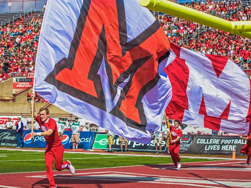 Dane Doebereiner runs across the Yager Stadium end zone with a white Miami flag. The scamper around the field is the Miami cheerleaders customary celebration when the football RedHawks score a touchdown.