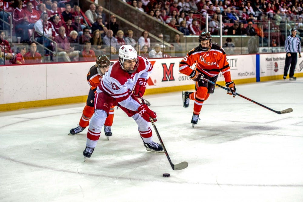 In his first collegiate game, freshman forward Ryan Savage handles the puck as two falcons bear down on him Sunday. Savage was held without a point, as his team lost 7-4.