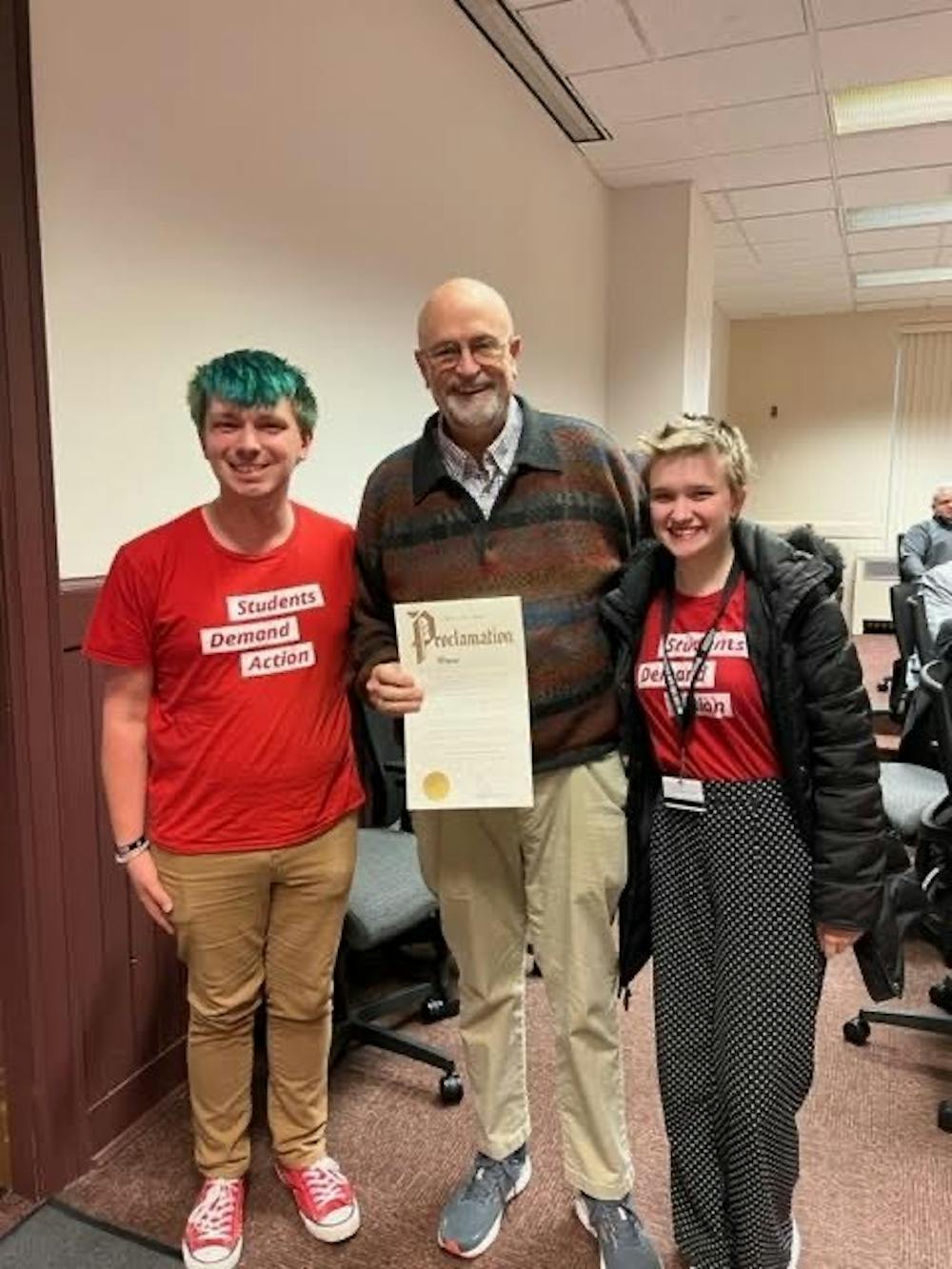 Venus Harvey (left) and Peren Tiemann (right) stand with Mayor William Snavely, who is holding the proclamation to declare June 2 as National Gun Violence Awareness Day in Oxford.