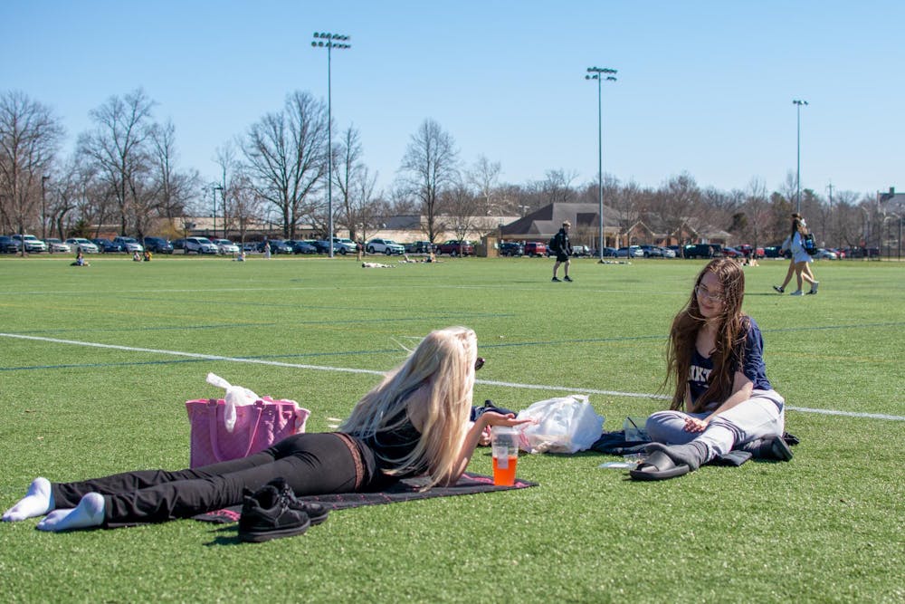 Students enjoy the warm weather by tanning on Cook Field. 