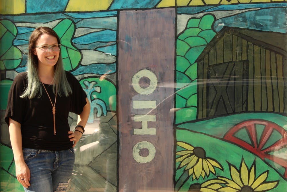 The thick black lines of Alyse Capaccio’s mural make it a stained glass style. The different panes honor the history between college and community with uptown park in the middle.