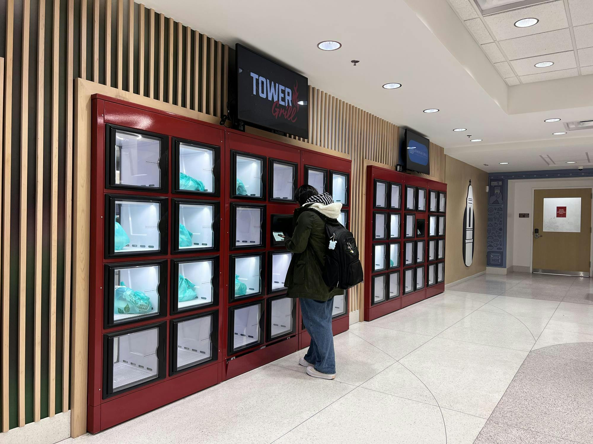 A student retrieves their food from the ghost kitchen at Bell Tower.