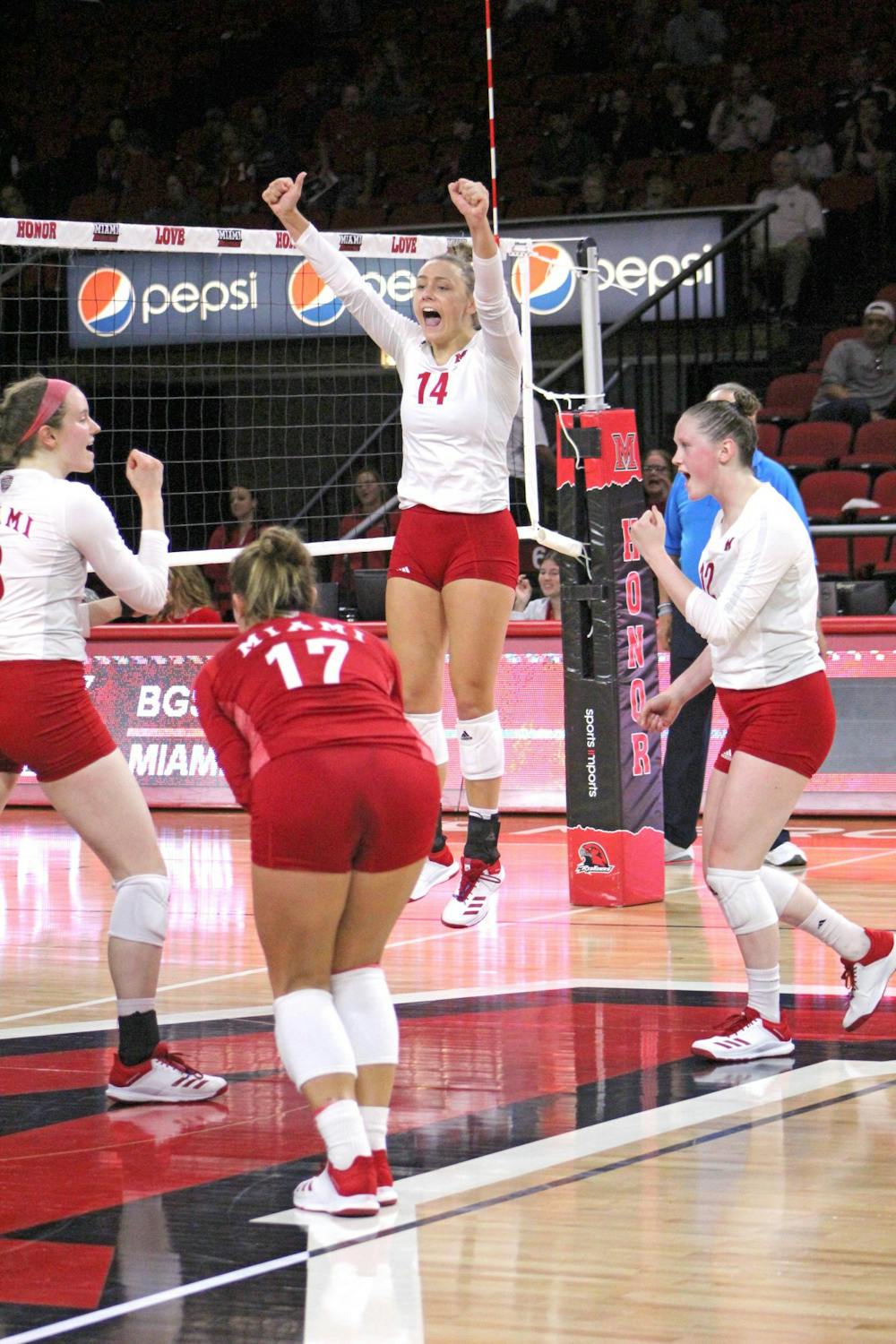 Junior right side Sarah Wojick jumps to celebrate a point with her teammates at Millett Hall. This season, Miami is 8-3 at home.